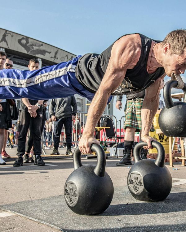 Man demonstrating a core strength exercise in a minimalist gym.